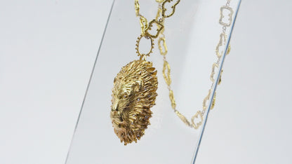 Pendentif Lion roi de la savane Cabinet de curiosité, bélière perlée, diamants et or jaune, accompagné de sa chaîne maille ciselée aux contours irréguliers en or jaune 18k 750/1000